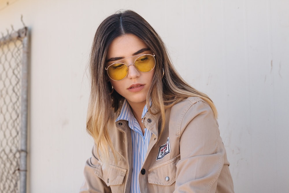 woman in brown button-up jacket near white painted wall