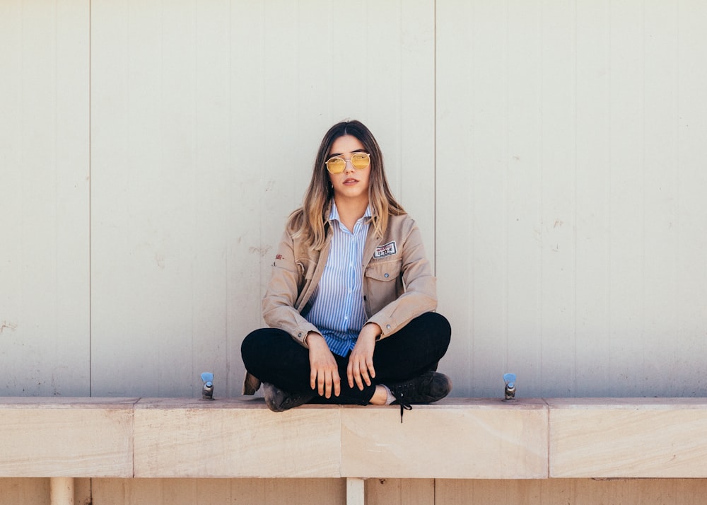 woman sitting on white concrete flooring