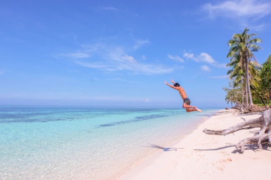 time-lapse photo of man jumping to the body of water in Palawan Philippines