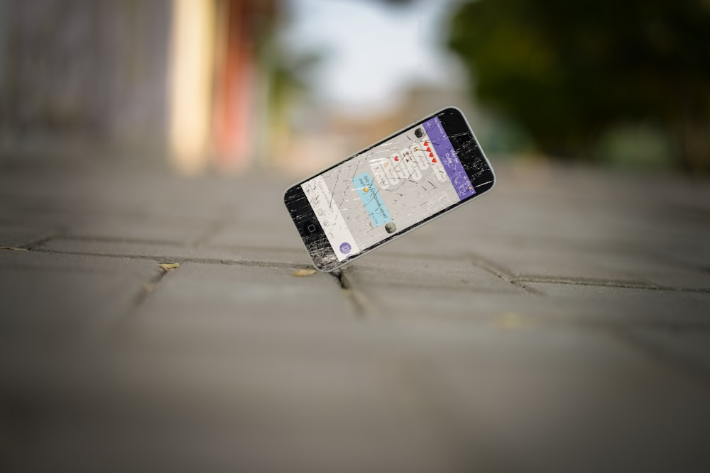 photo de mise au point sélective de l’équilibre de l’iPhone sur le trottoir de briques