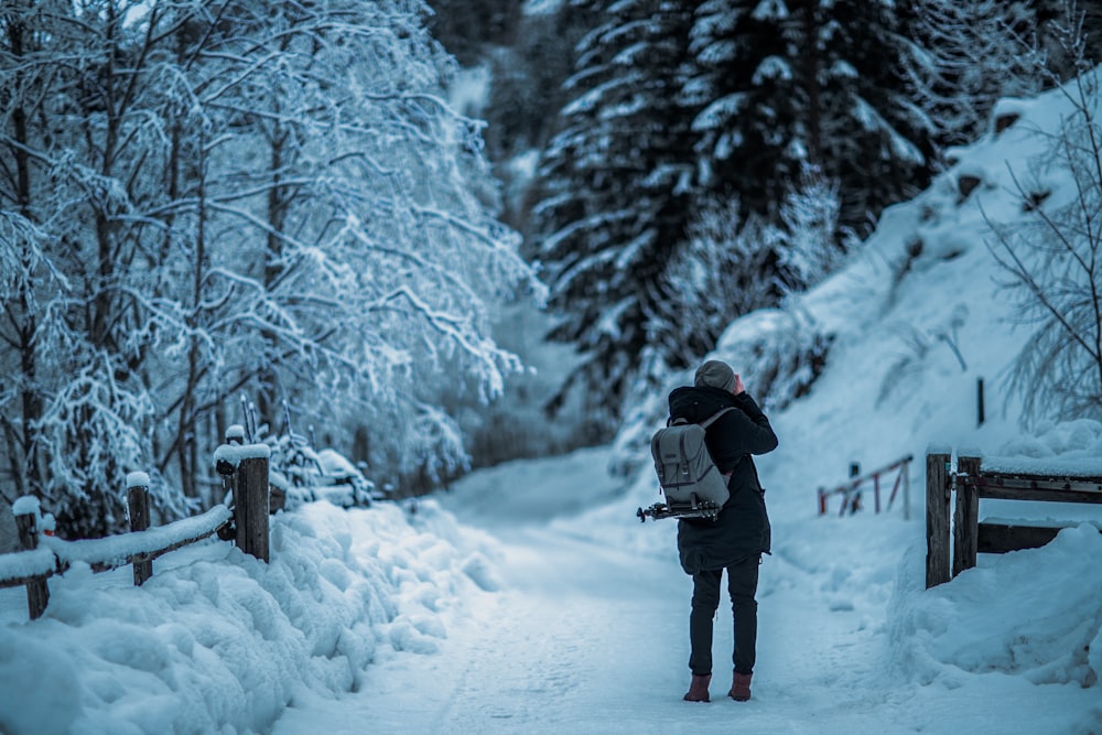 man standing in middle of snowfield during daytime