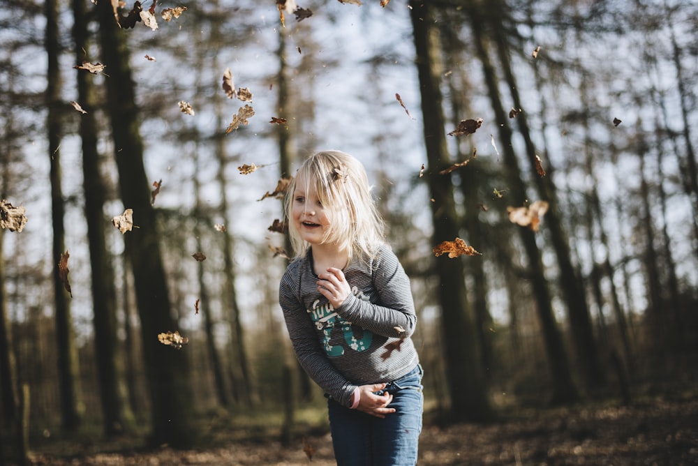 menina em cinza de manga comprida top correndo cercado de árvores