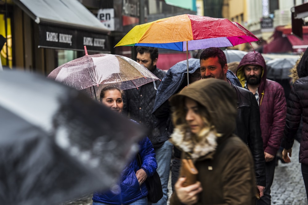 homme et femme tenant des parapluies