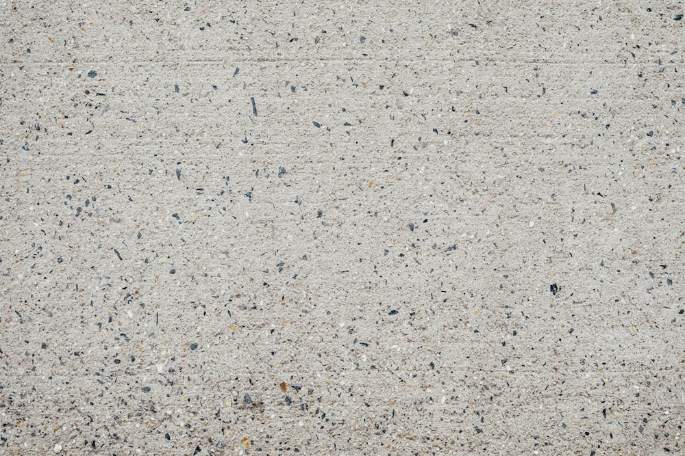 작은 검은 점들이 있는 시멘트 표면의 클로즈업