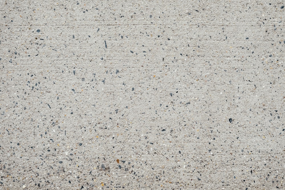 a close up of a cement surface with small black dots