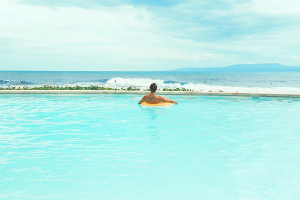 A happy traveler relaxing by the pool of a charming island villa.