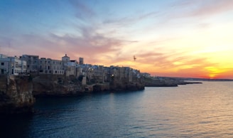 A vibrant photo of travelers exploring a scenic coastal town at sunset.