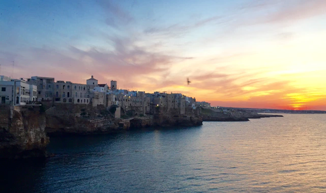 A breathtaking view of a serene European coastal town at sunset, inviting exploration.