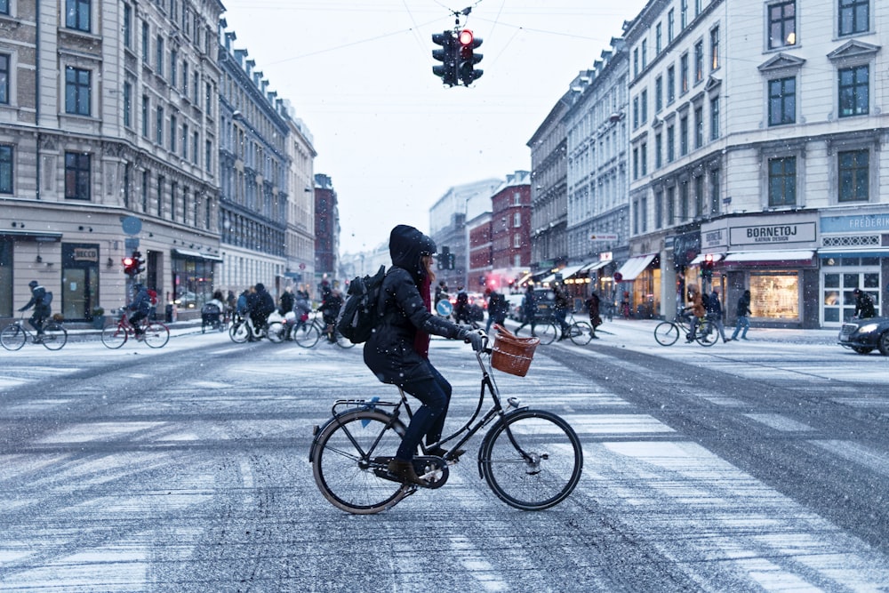 person cyclist near concrete buildings