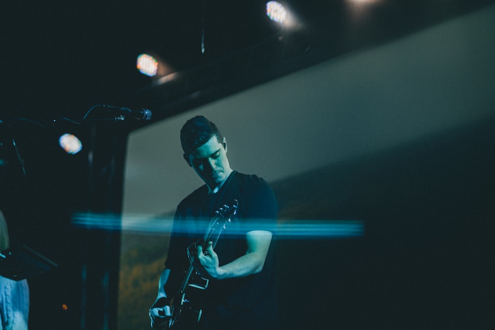 man playing guitar on stage