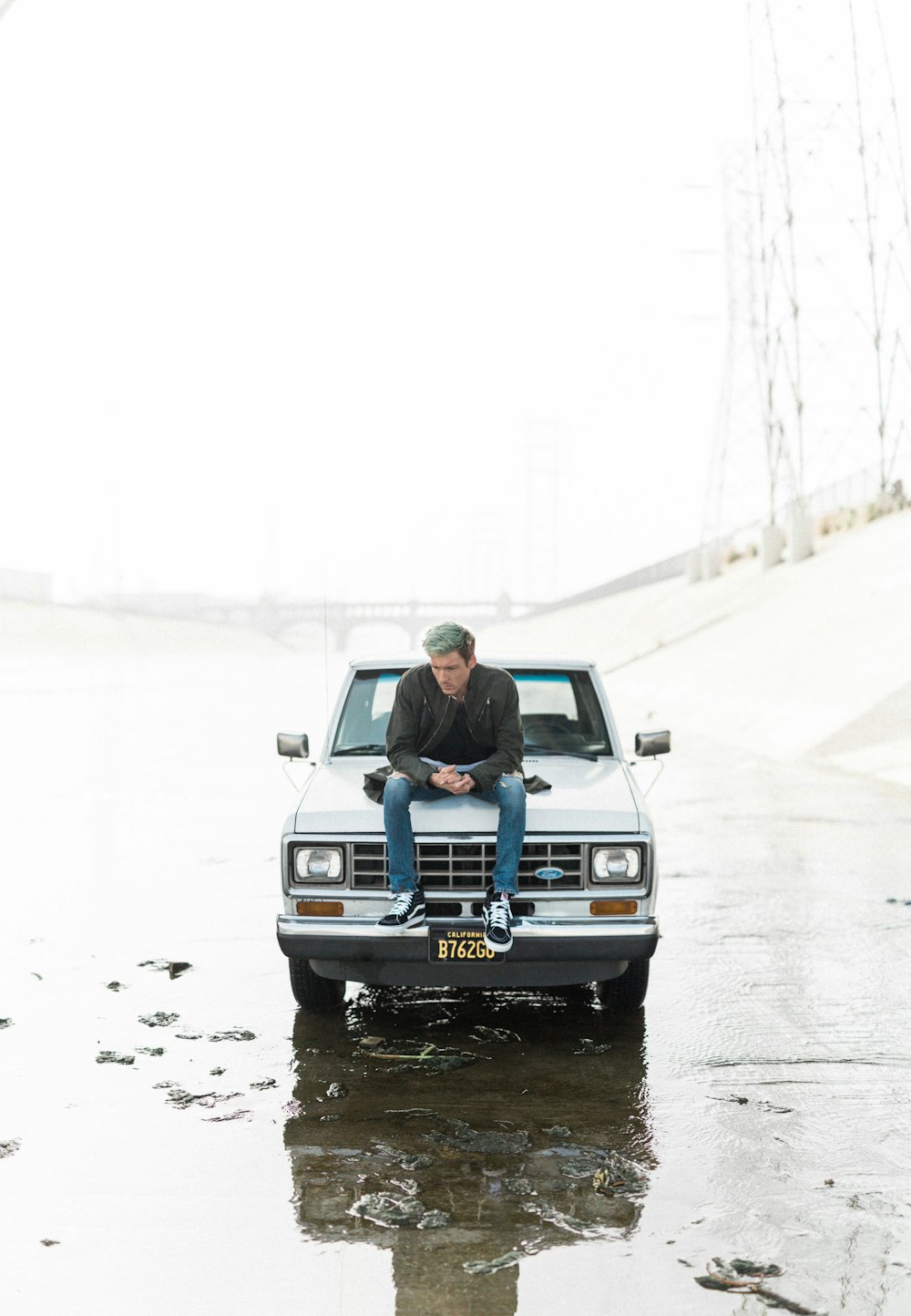 man sitting on car hood