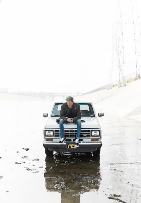 man sitting on car hood in Los Angeles United States