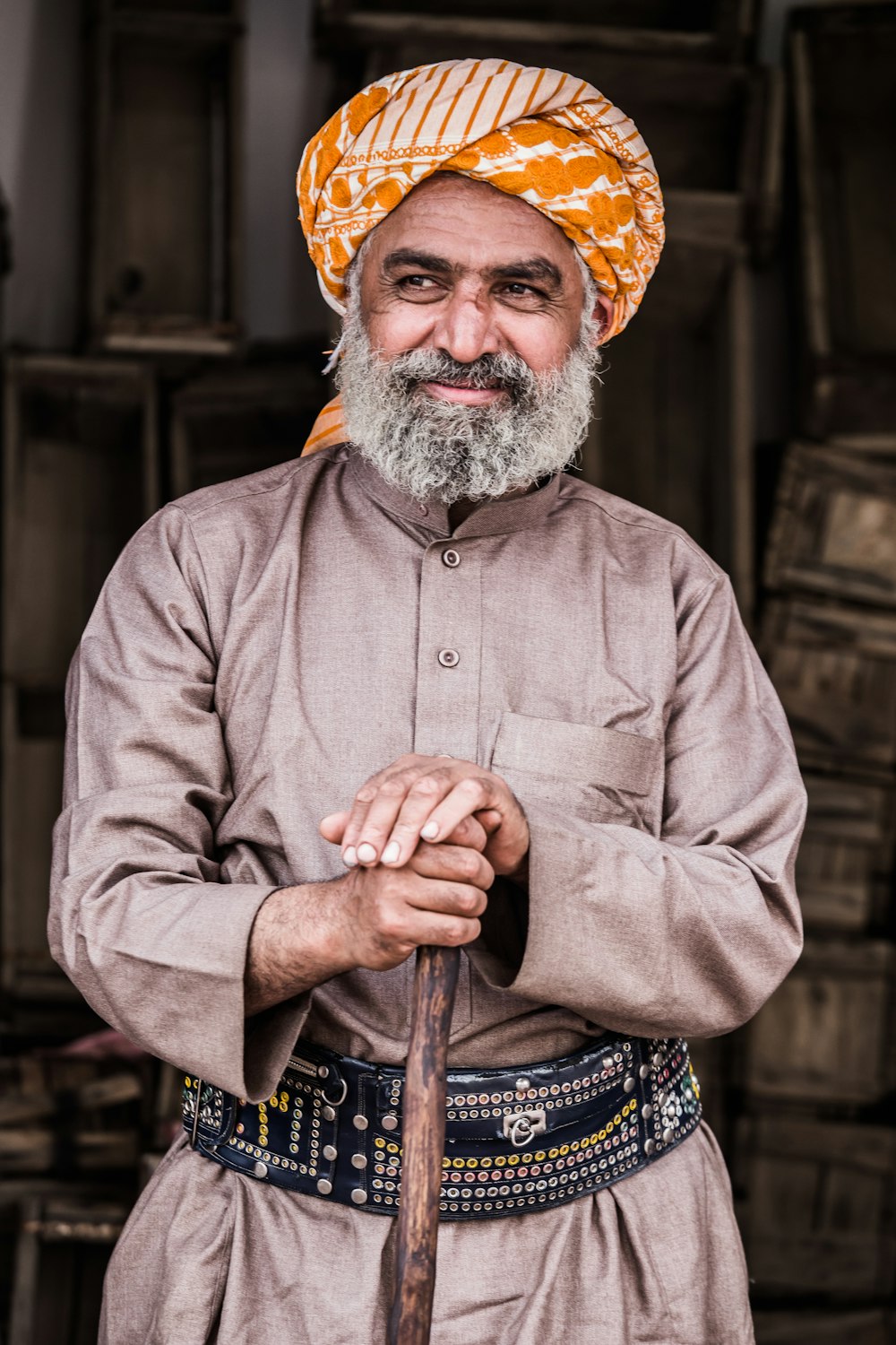 man standing while holding brown wooden walking cane