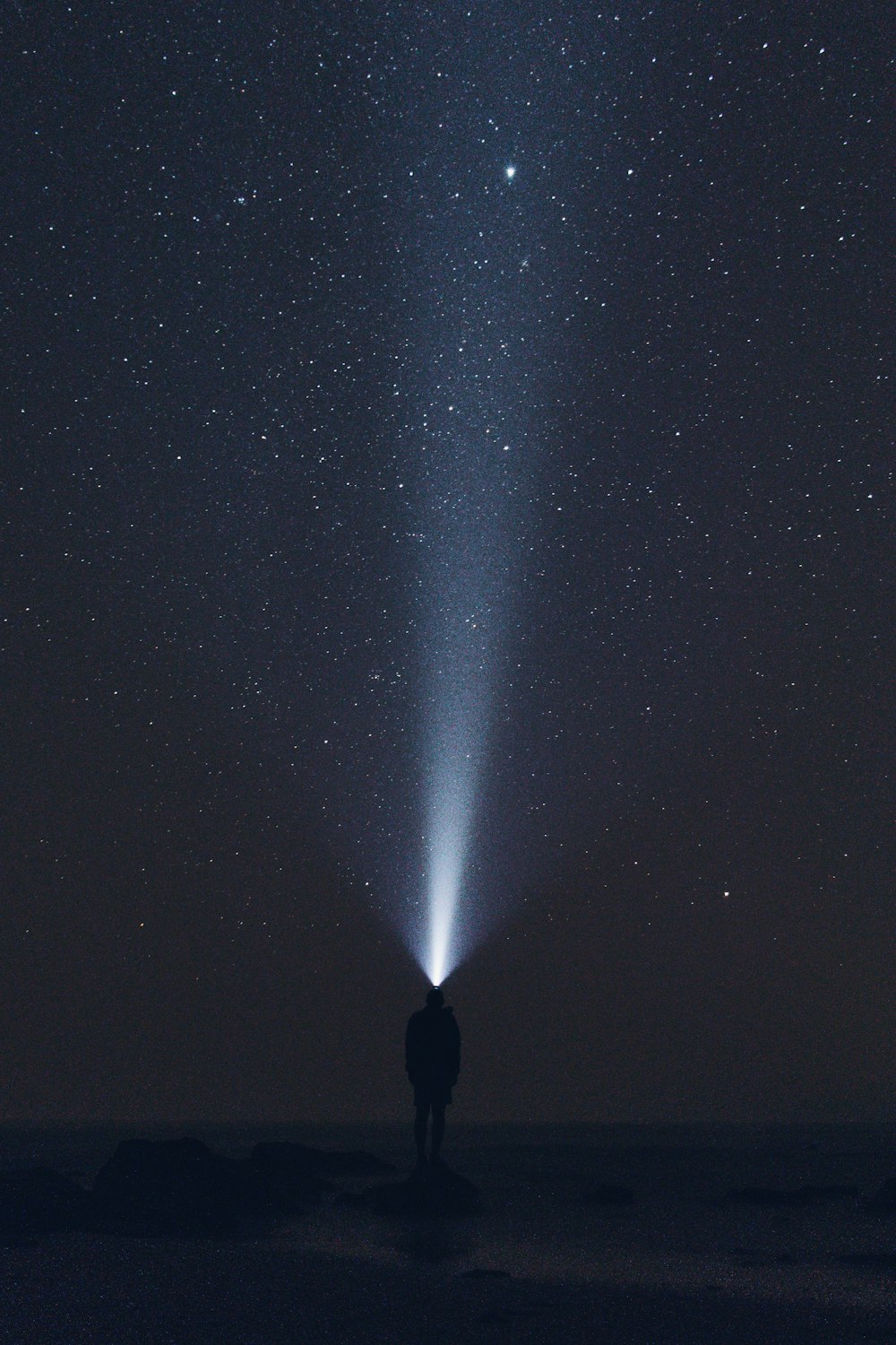 silhouette d’homme portant une lampe frontale pendant la nuit
