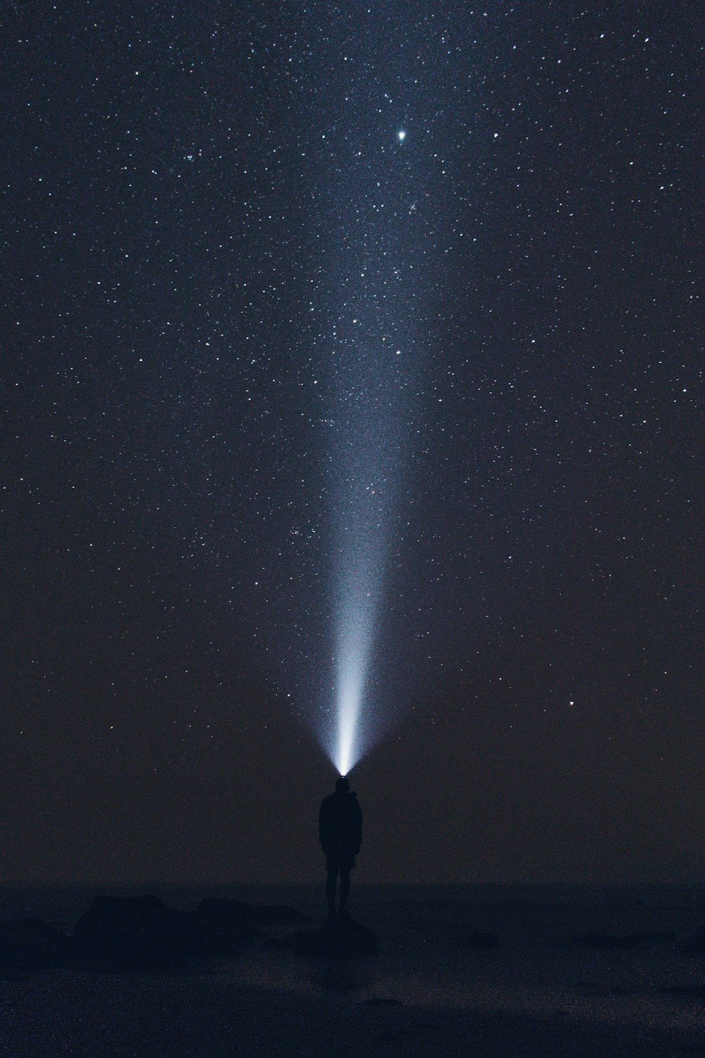 silhouette of man wearing headlamp during nighttime