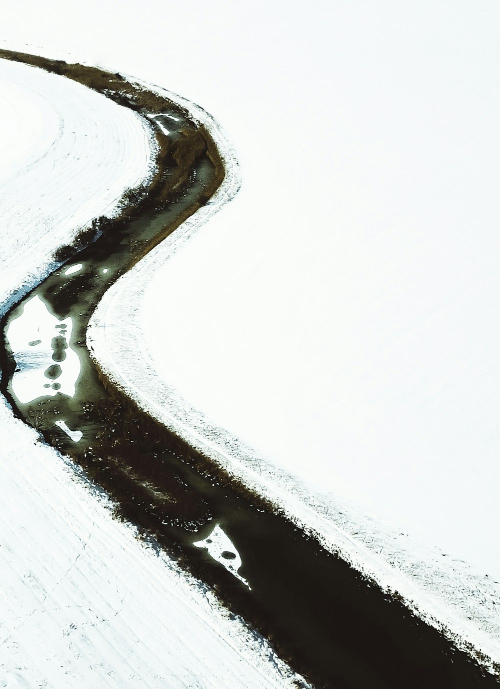 river surrounded with snow at daytime