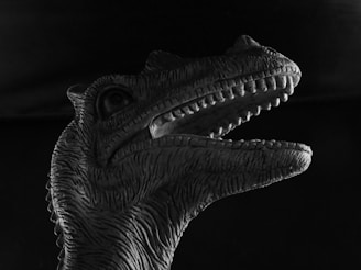 A black Tyrannosaurus rex sitting on a hunebed, eating a steak, with a light-colored background.