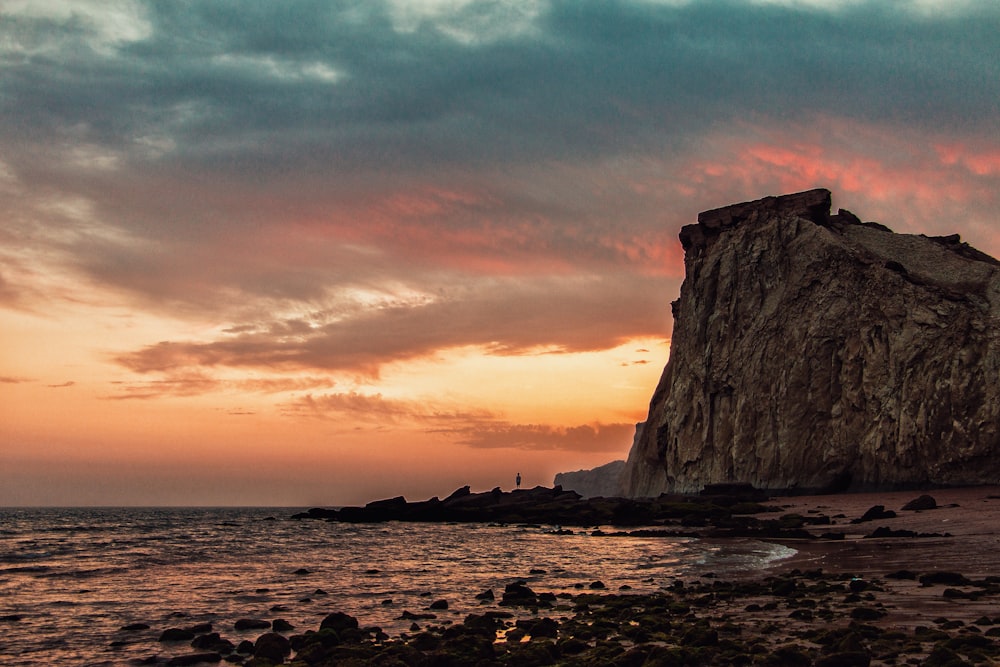 brown cliff near body of water during golden hour