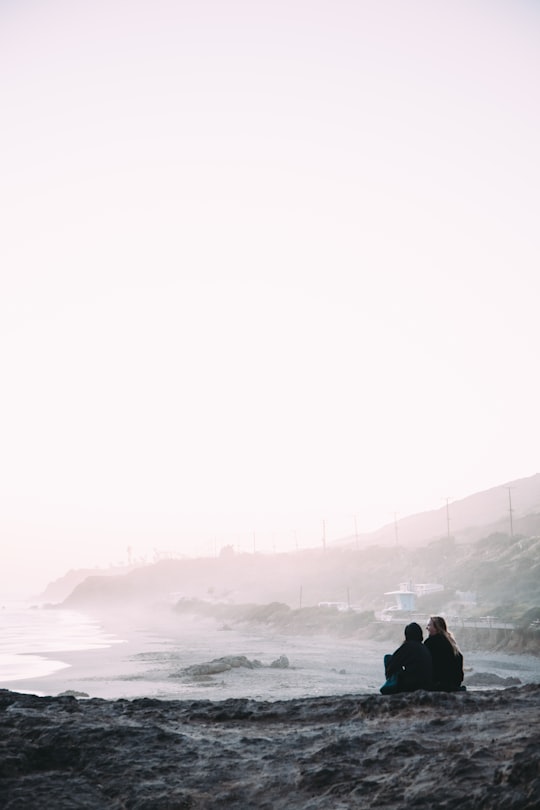 two person sitting beside shore in Malibu United States