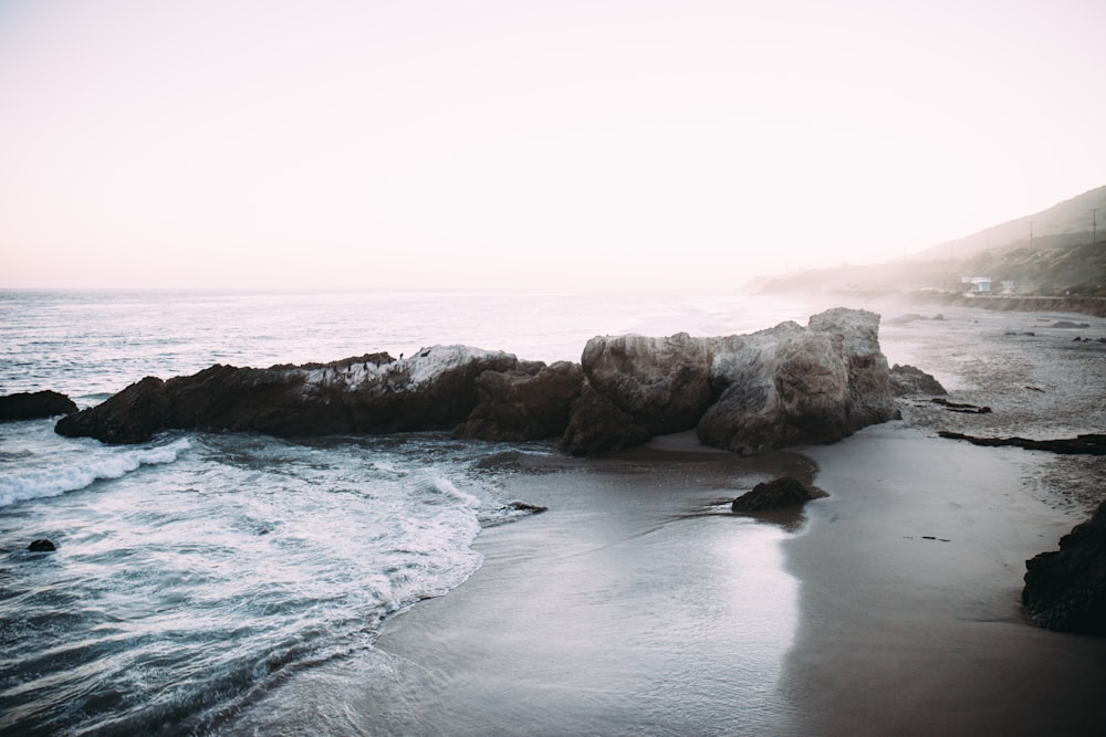 grey rock formation at the seashore during daytime