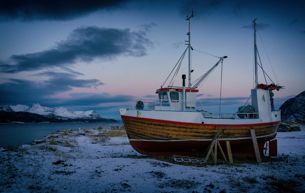 brown and white boat on white sand beach