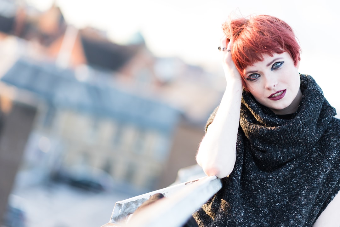 woman wearing black coat touching her hair