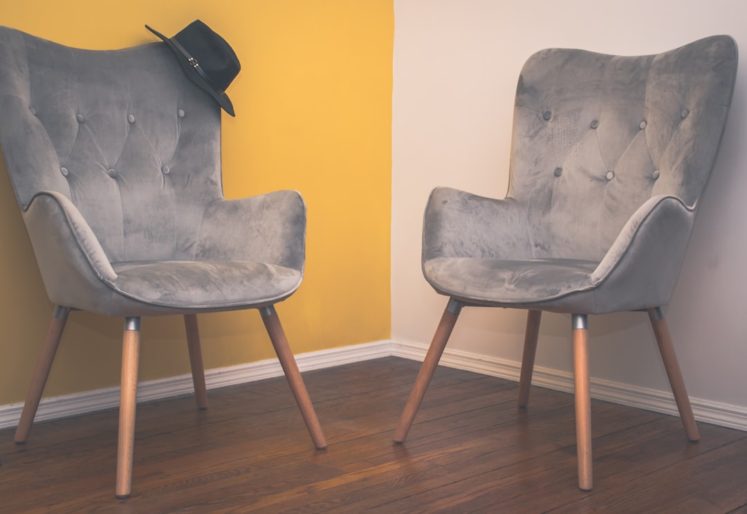 gray padded chair on brown wooden floor