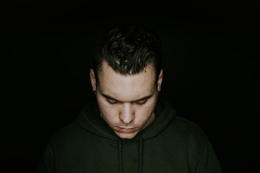 man in green pullover hoodie looking down