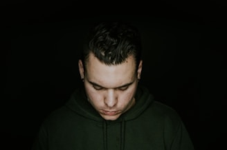 man in green pullover hoodie looking down