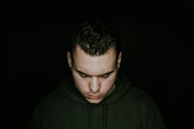 man in green pullover hoodie looking down