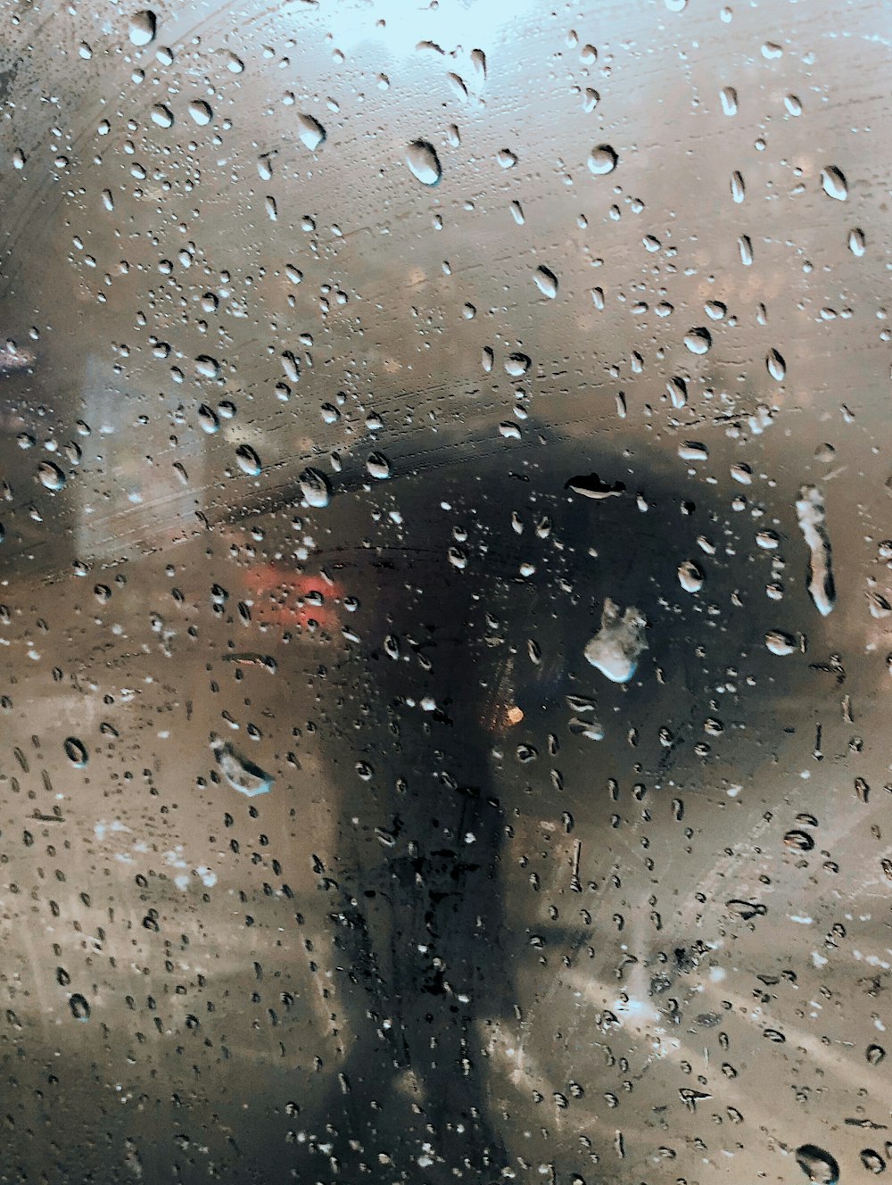 a person standing in the rain holding an umbrella