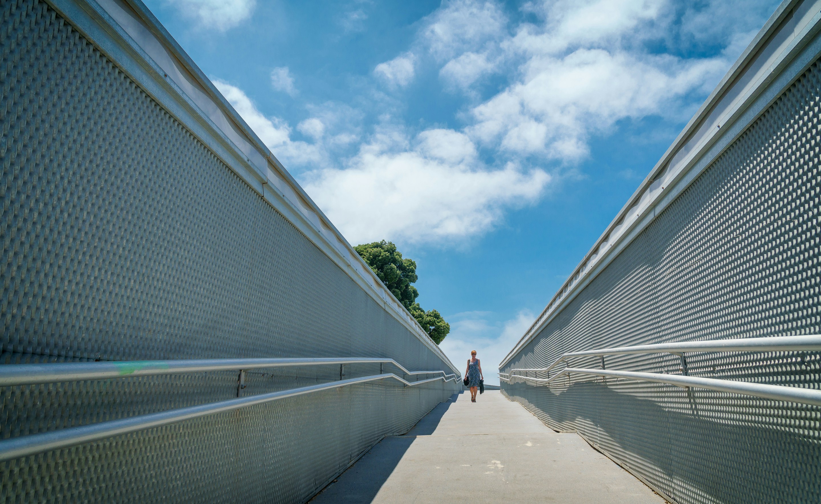 woman walking in the middle of concrete walls
