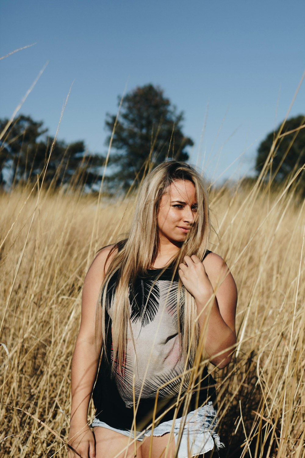 woman in black tank top standing on grass field