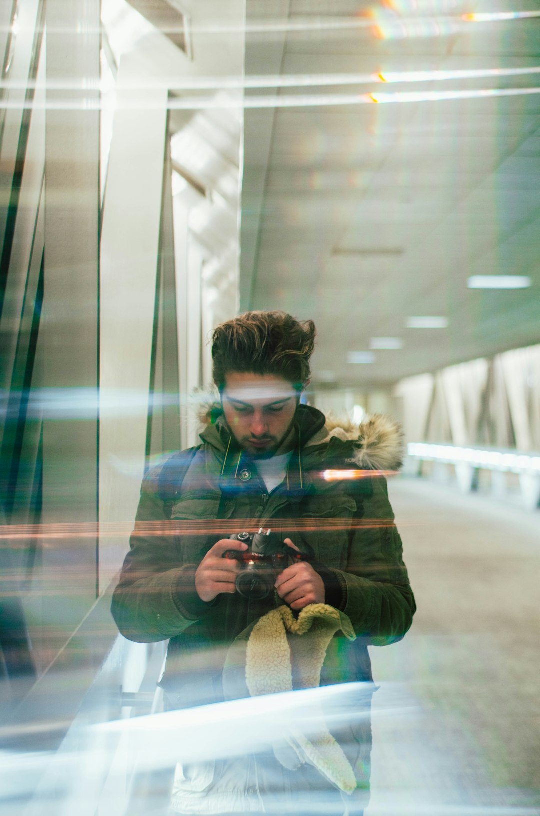 man looking at red camera while standing inside building