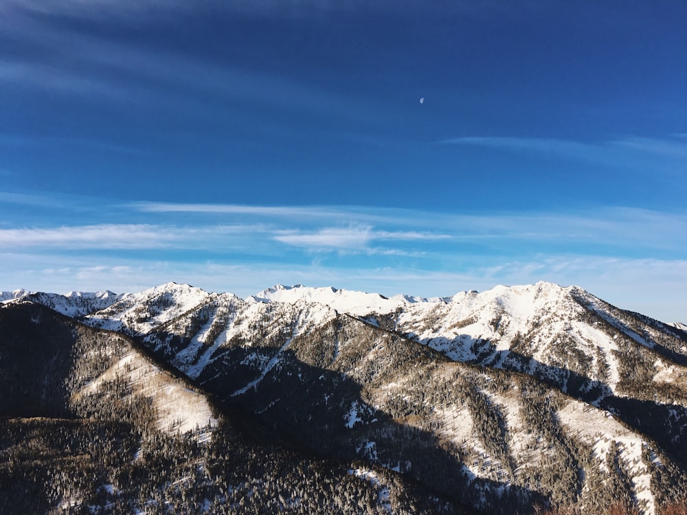 Weiße und braune Berge unter weißen Wolken und blauem Himmel am Tag