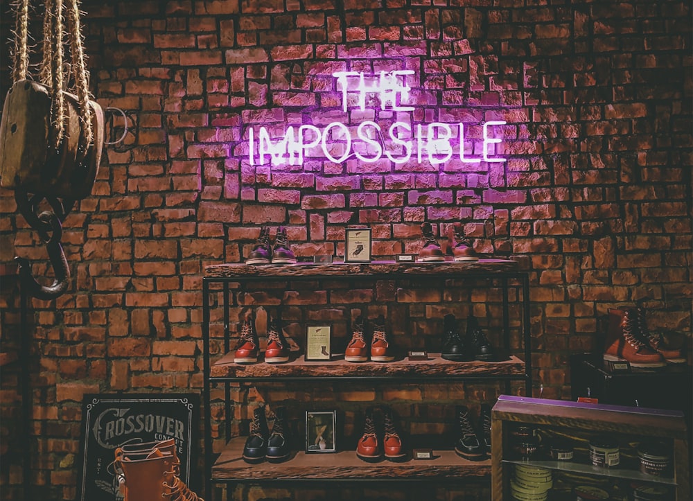 Letreros de luces de neón de The Impossible en una pared de ladrillo