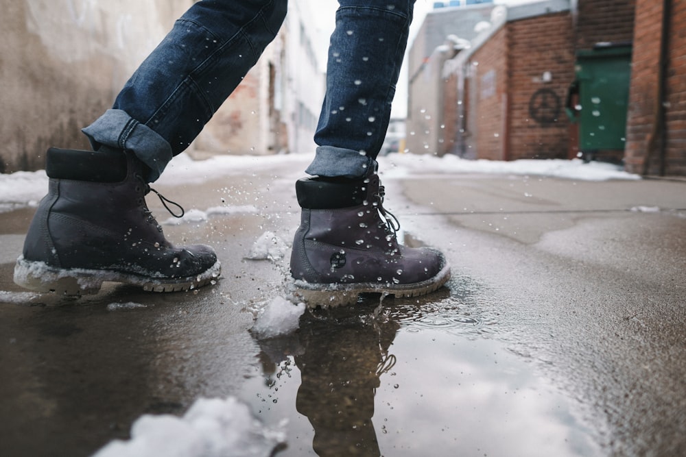 Person, die ein Paar graue Lederstiefel trägt