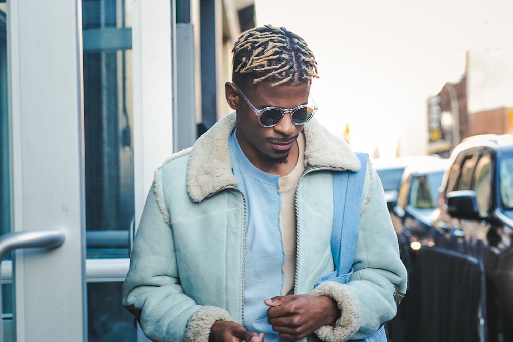 man in teal zip-up jacket and sunglasses