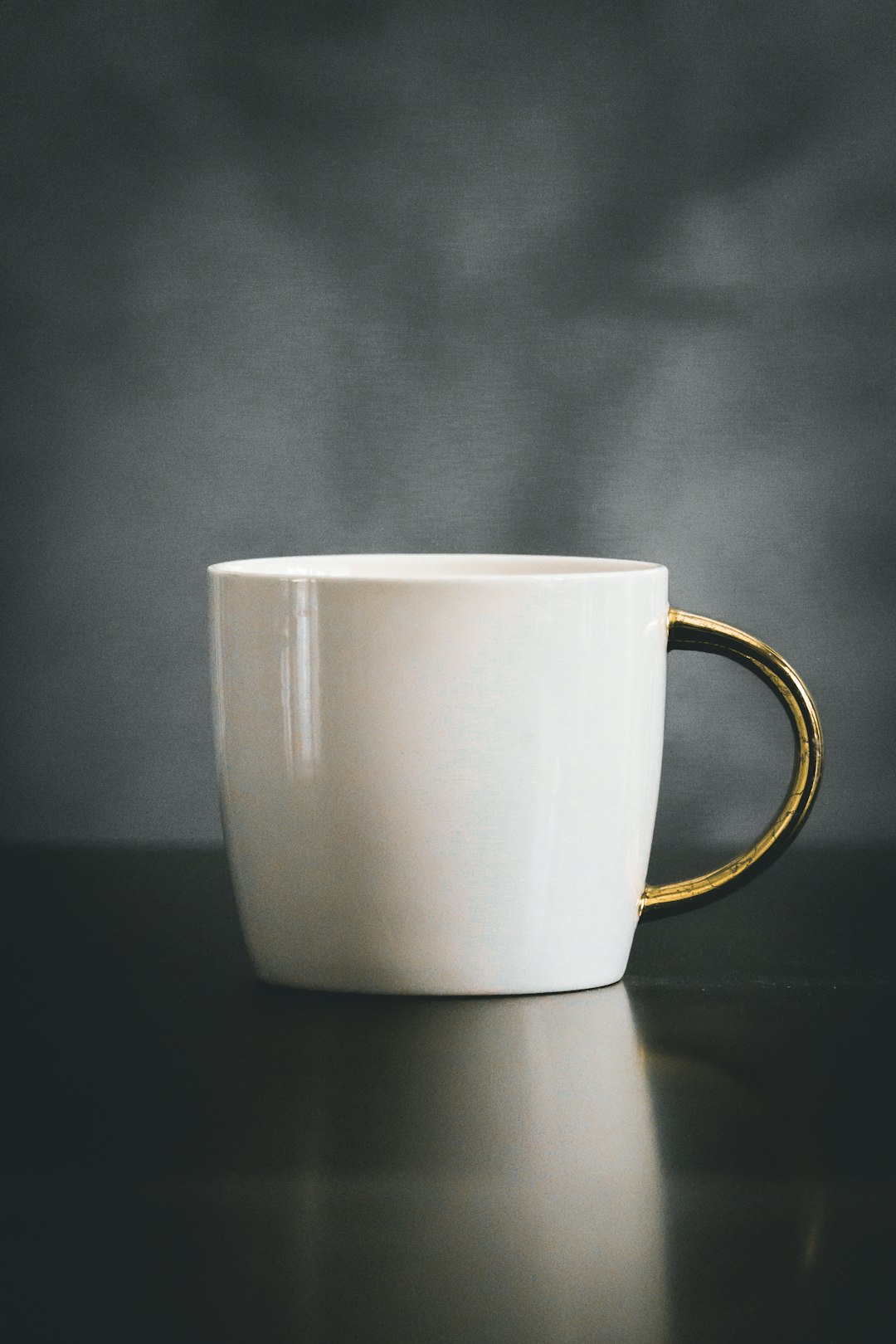  white and beige ceramic mug on black surface cup