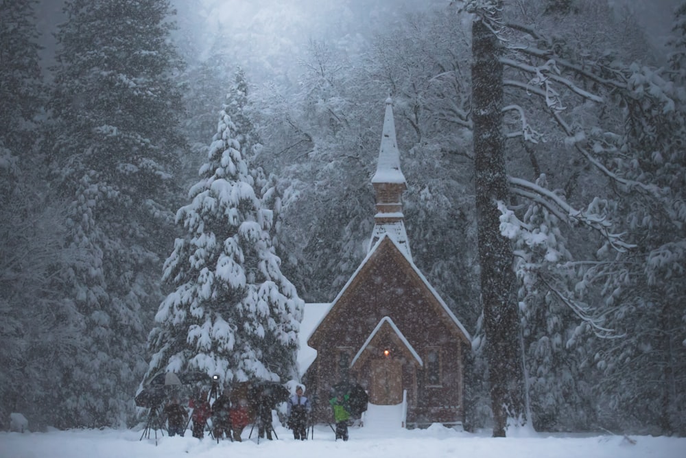 Menschen, die vor Kirche und Wald stehen