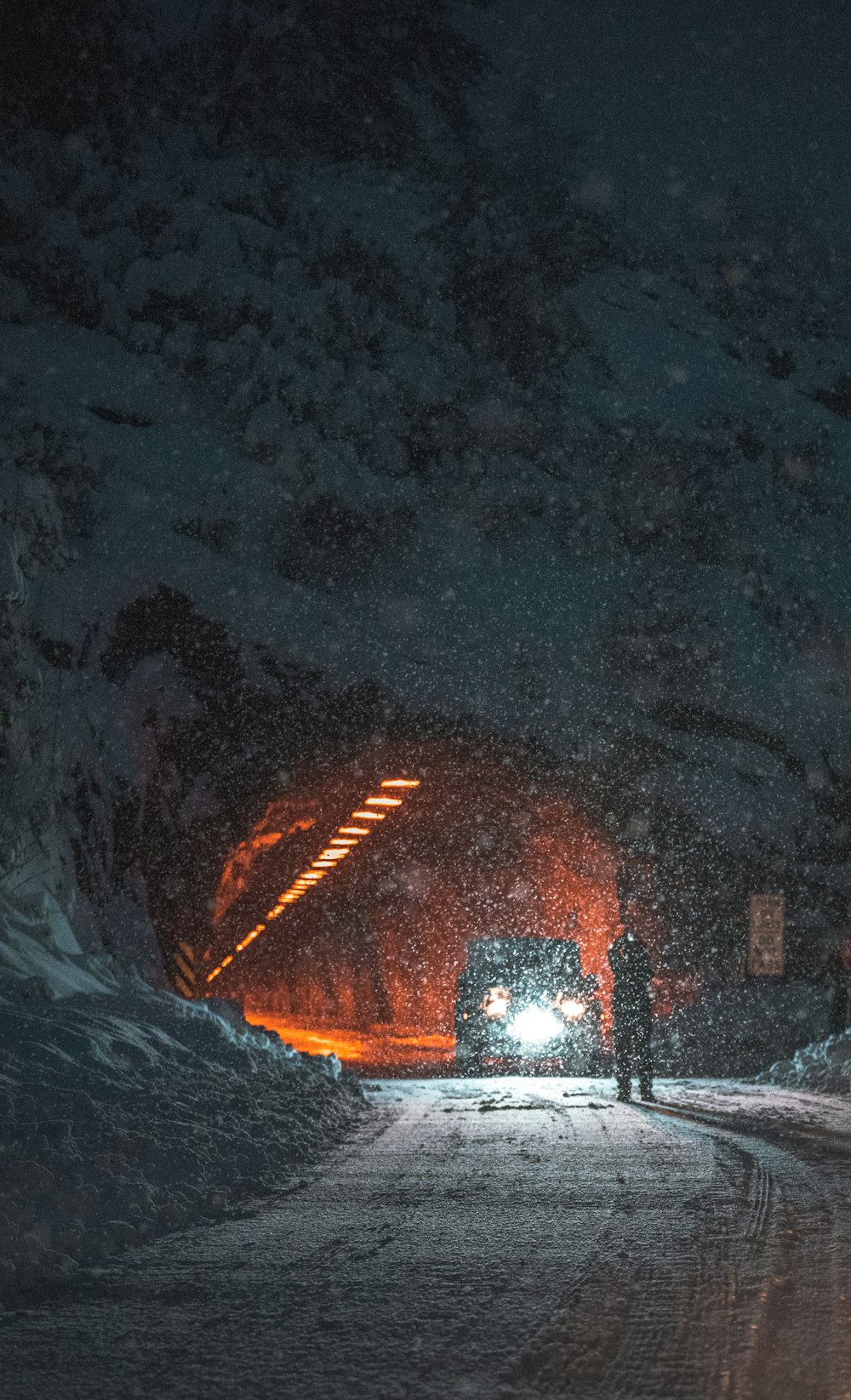 person standing on concrete road near tunnel