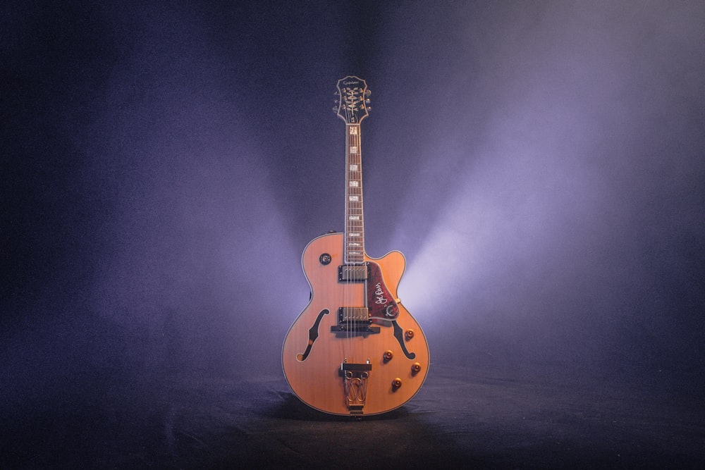 brown and black jazz guitar with dim light