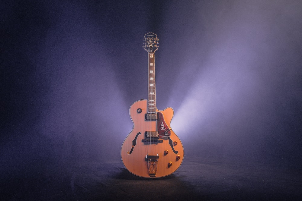 Guitarra de jazz marrón y negro con luz tenue