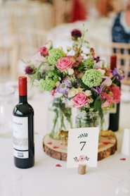 flower arrangement with wine bottle on the table