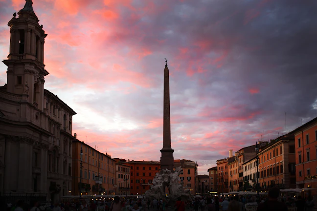 Sunset view of the Obelisk surrounded by city lights in Buenos Aires.