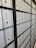 A row of metal post office boxes with numbers and keyholes, arranged in a grid pattern, creating a repetitive and organized visual effect. The boxes are metallic silver with black numerals and are framed by a black structure.