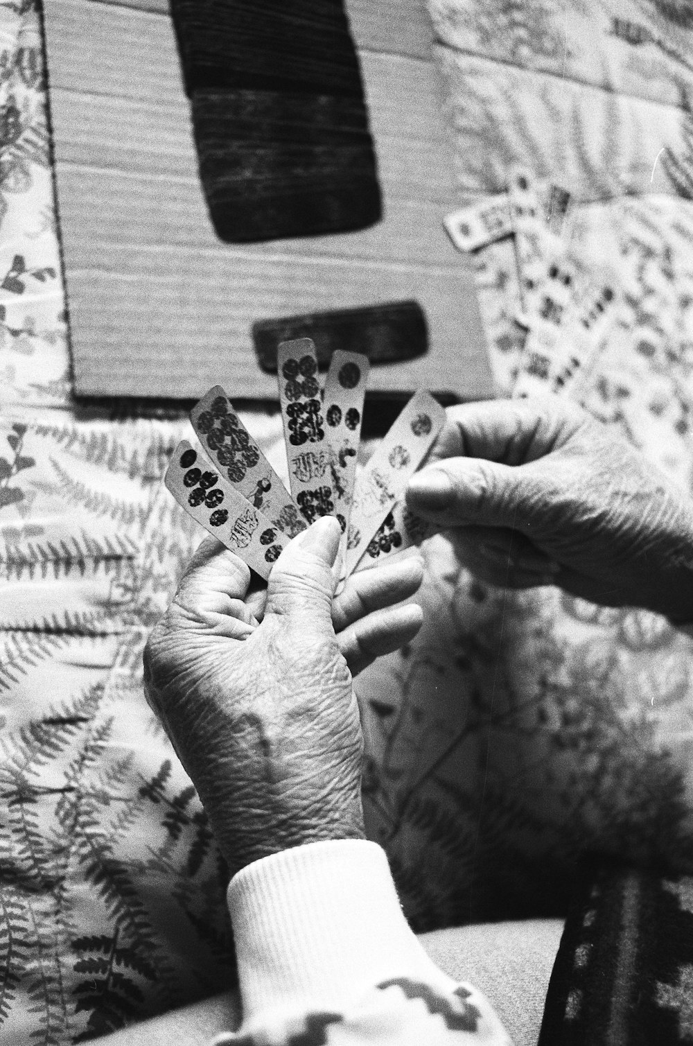 grayscale photo of person holding game chips