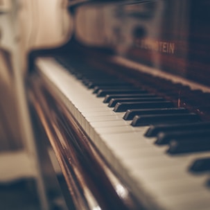 a close up of a piano with a person in the background