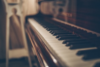 a close up of a piano with a person in the background