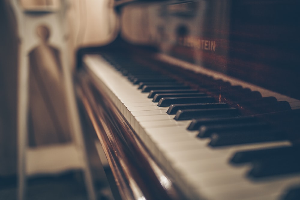 um close up de um piano com uma pessoa ao fundo